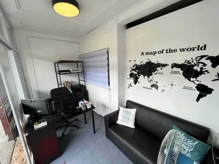 Inside the Crownways Travel Center office in Mendez, Cavite, with a world map mural and client lounge